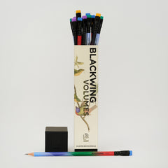 Blackwing Volumes pencil box with bird illustration, lid off to the side with tops of colorful pencil erasers poking out and one pencil laying horizontal at the base of the box