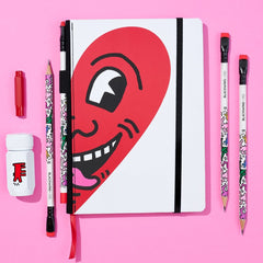 Blackwing Vol. 292 Keith Haring gift set featuring a notebook with Haring’s smiling heart illustration on a pink background