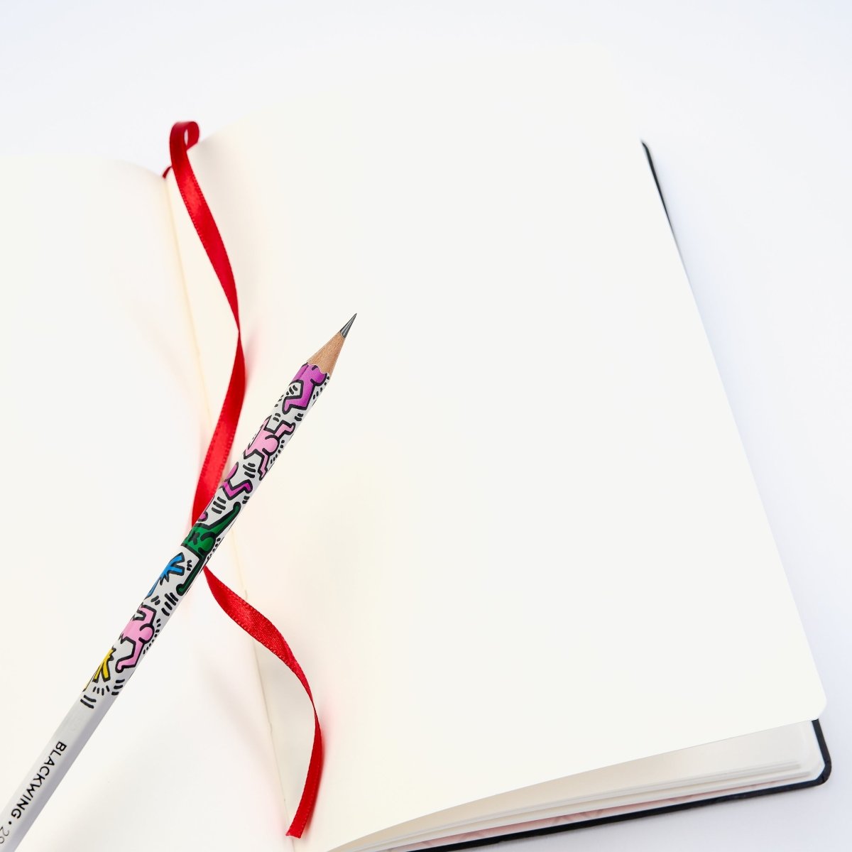 Blackwing Volume 292 - Keith Haring "Tokyo Pop-Shop" Notebook lays open on a table with a Vol. 292 pencil on top