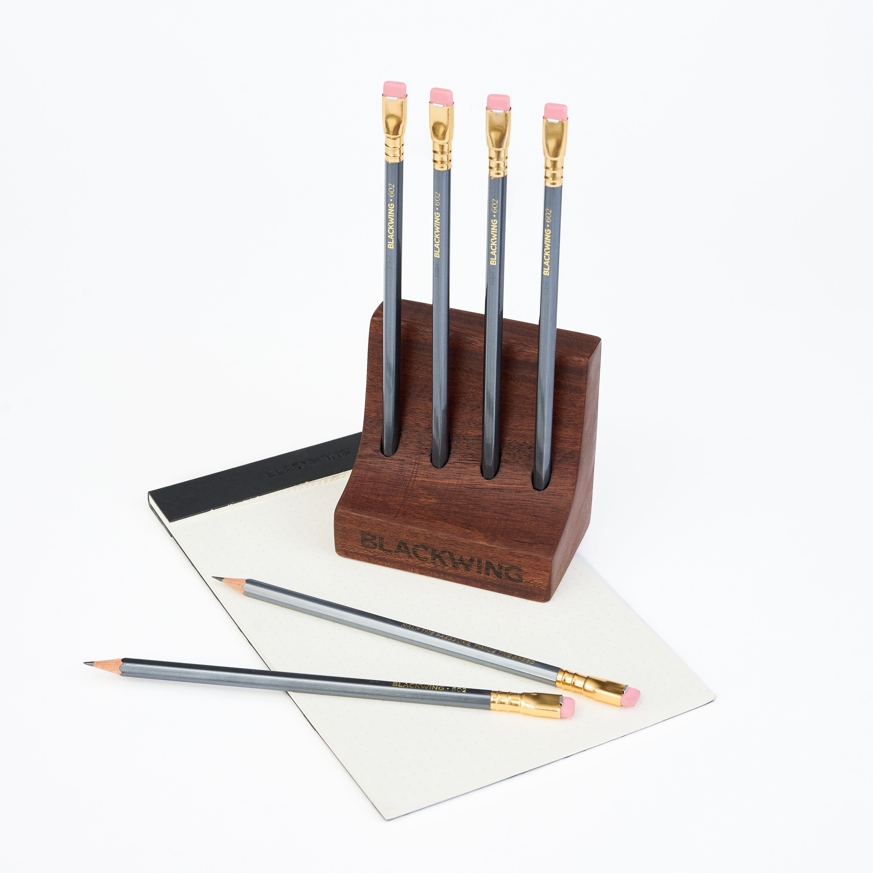 zapatero wood pencil stand with four Blackwing pencils on top of a white background with a legal pad