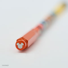 A close-up of a Disney pencil with a bright red point guard featuring a silver Mickey Mouse silhouette, shown on a clean white background with the rest of the pencil blurred due to a shallow depth of field.