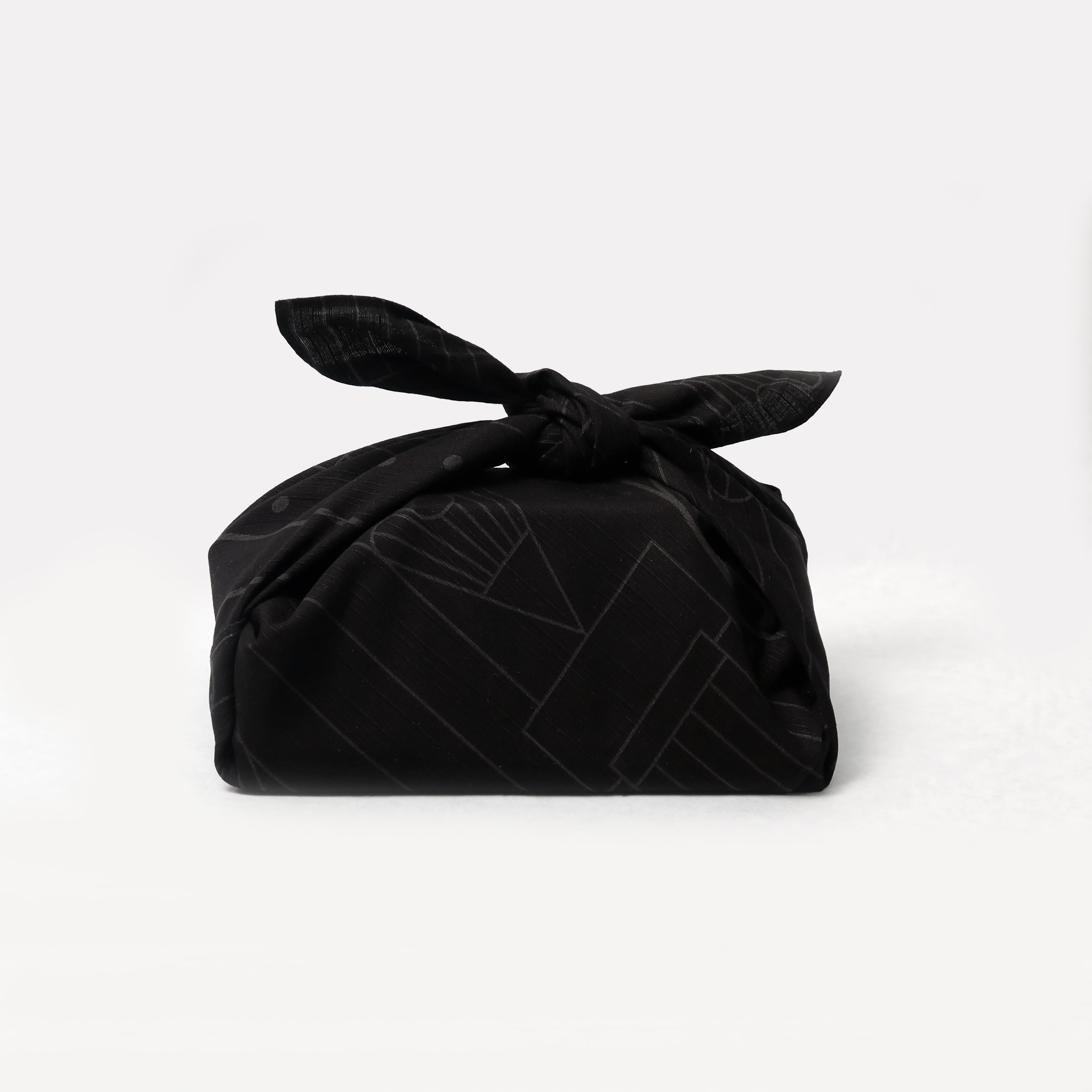 A black bag with a Blackwing Furoshiki (Japanese Cloth Wrapping Paper) tied around it.