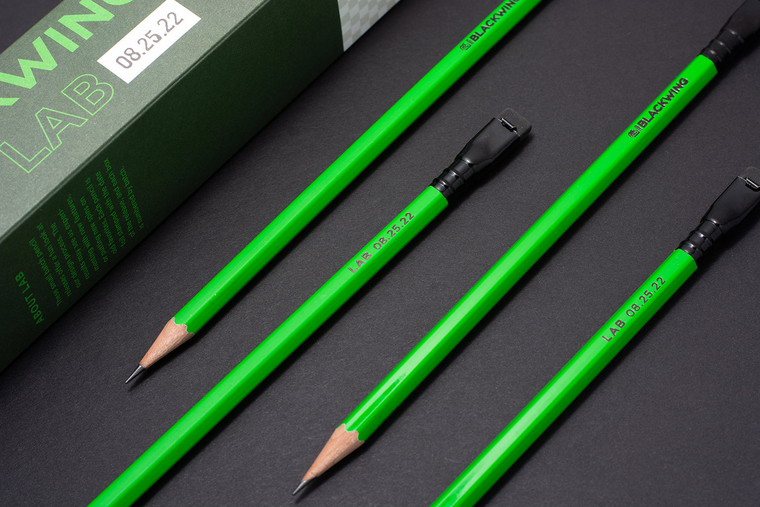 A set of Blackwing Lab 08.25.22 green pencils next to a box.